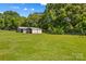 Large, grassy backyard with metal outbuildings, providing ample storage space at 124 Island Park Ln, Statesville, NC 28625