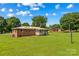 Large backyard with a brick house, shed, and mature trees in the background at 124 Island Park Ln, Statesville, NC 28625