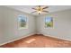 This bedroom offers natural light, hardwood floors, and a ceiling fan at 124 Island Park Ln, Statesville, NC 28625