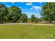 Expansive front yard showcasing lush lawn and mature trees, all within a fenced perimeter at 124 Island Park Ln, Statesville, NC 28625