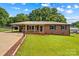 Charming single-story brick home featuring a metal roof, well-maintained lawn, and a convenient carport at 124 Island Park Ln, Statesville, NC 28625