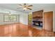 Living room showcasing a brick fireplace, hardwood floors, and natural light from the adjacent windows at 124 Island Park Ln, Statesville, NC 28625