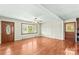 Bright living room with gleaming hardwood floors, a ceiling fan, and a front door with decorative glass at 124 Island Park Ln, Statesville, NC 28625