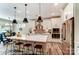 Bright kitchen features stainless steel appliances, pendant lighting, white cabinets and a large island with stools at 126 Longwood Rd # 52, Mooresville, NC 28115