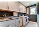 Modern laundry room with white cabinets, gray countertops, and stainless steel washer and dryer at 126 Longwood Rd # 52, Mooresville, NC 28115