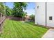 Green backyard area with a wooden fence and stone retaining wall, perfect for outdoor enjoyment at 129 French St, Charlotte, NC 28216
