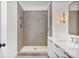 Elegant bathroom featuring a walk-in shower, marble countertop, and modern gold-tone light fixtures at 129 French St, Charlotte, NC 28216