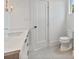 Bathroom with marble countertop, tile flooring, toilet, and modern gold-tone light fixture at 129 French St, Charlotte, NC 28216