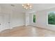 A bright bedroom featuring hardwood floors, neutral walls, and natural light from a single window at 129 French St, Charlotte, NC 28216