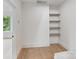 Bright bedroom featuring hardwood floors, neutral walls, and open shelving at 129 French St, Charlotte, NC 28216