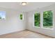 A bright bedroom featuring hardwood floors, neutral walls, and natural light from multiple windows at 129 French St, Charlotte, NC 28216