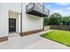 Exterior side view of a modern home featuring an entryway with a balcony and landscaped yard at 129 French St, Charlotte, NC 28216