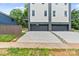 Street view of modern home featuring a two-car garage, landscaped front yard, and private drive at 129 French St, Charlotte, NC 28216