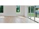 Bright living room featuring hardwood floors, large windows, and sliding glass door to the balcony at 129 French St, Charlotte, NC 28216