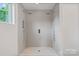 A luxurious walk-in shower with double shower heads, sleek tile, and built-in shelving at 129 French St, Charlotte, NC 28216
