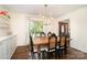 Charming dining room with hardwood floors, a large wooden table, a brass chandelier, and ample natural light at 139 Palaside Ne Dr, Concord, NC 28025