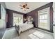 A bedroom with dark purple walls, ceiling fan, and carpet flooring at 14533 Holly Springs Dr, Huntersville, NC 28078