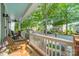 View of the tree lined street from the front porch with rocking chairs and a painted blue ceiling at 14533 Holly Springs Dr, Huntersville, NC 28078