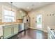 Bright kitchen featuring stainless steel appliances, green cabinets, and backyard access at 14533 Holly Springs Dr, Huntersville, NC 28078