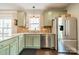 Well-lit kitchen with stainless steel appliances, stylish green cabinetry, and granite countertops at 14533 Holly Springs Dr, Huntersville, NC 28078