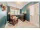 Cozy sitting area in bedroom with a plush chair, side table, and natural lighting at 14533 Holly Springs Dr, Huntersville, NC 28078