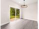 Bright dining area with sliding glass doors leading to a deck, wood-look floors, and modern lighting at 1471 Marshbrooke Ln, Catawba, NC 28609