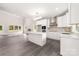 Open-concept layout showcases the kitchen's white cabinets, island, and stainless steel appliances with gray wood floors at 1471 Marshbrooke Ln, Catawba, NC 28609