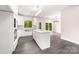 A bright and modern kitchen boasts white cabinets, an island, stainless appliances, and gray wood floors at 1471 Marshbrooke Ln, Catawba, NC 28609