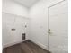 A simple laundry room with white walls, a door, hookups, a wire rack, and gray wood floors at 1471 Marshbrooke Ln, Catawba, NC 28609