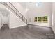 Bright living room featuring gray wood floors, a staircase, and large windows offering natural light at 1471 Marshbrooke Ln, Catawba, NC 28609