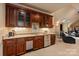 Entertainment area with a custom wet bar, dark wood cabinets, and stainless steel beverage center in the basement at 1500 Lookout Cir, Waxhaw, NC 28173