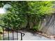 Landscaped backyard with stone patio, garden area, and wrought iron fence at 153 Perrin Pl, Charlotte, NC 28207