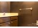 Modern half-bathroom featuring a dark accent wall with gold fixtures and a vanity with dark wood cabinets at 153 Perrin Pl, Charlotte, NC 28207