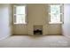 Spacious room featuring a fireplace and two windows with shutter blinds, neutral carpeting at 153 Perrin Pl, Charlotte, NC 28207