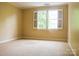 Bright bedroom featuring a large window and neutral carpeted floors throughout the space at 153 Perrin Pl, Charlotte, NC 28207