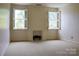 Spacious room with fireplace, two windows with shutter blinds and neutral carpeted flooring at 153 Perrin Pl, Charlotte, NC 28207
