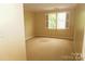 A simple bedroom featuring carpeted floors and a large window offering natural light at 153 Perrin Pl, Charlotte, NC 28207