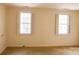 Bright bedroom with neutral walls, carpet, and two large windows with plantation shutters at 153 Perrin Pl, Charlotte, NC 28207