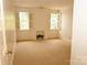 Bright bedroom featuring two windows with shutters, a carpeted floor, and a non-functional fireplace at 153 Perrin Pl, Charlotte, NC 28207