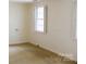 Light-filled bedroom with window dressed with shutter blinds and neutral-colored walls at 153 Perrin Pl, Charlotte, NC 28207