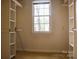 Well-organized walk-in closet with window and custom shelving for optimal storage solutions at 153 Perrin Pl, Charlotte, NC 28207
