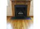 Detailed view of a fireplace with a wood mantel and black surround, complemented by hardwood floors at 153 Perrin Pl, Charlotte, NC 28207