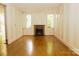 Charming living room with hardwood floors, decorative fireplace, and large windows at 153 Perrin Pl, Charlotte, NC 28207