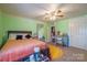 Bedroom features a cozy bed, blue writing desk, walk-in closet, and a yellow circular rug at 153 S Center St, Taylorsville, NC 28681