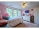 Light-filled pink bedroom featuring a bed, dresser with TV, and three large windows at 153 S Center St, Taylorsville, NC 28681