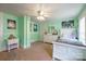 Bedroom in light green featuring dual windows and bed set between a dresser and desk at 153 S Center St, Taylorsville, NC 28681