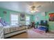 Bedroom in light green featuring dual windows and bed set between a dresser and desk at 153 S Center St, Taylorsville, NC 28681