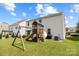 Landscaped backyard with a play structure, swing set, and comfortable seating area at 1569 Shannon Falls Dr, Fort Mill, SC 29715