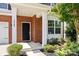 A welcoming brick porch with white pillars and a black front door, accented by lush greenery at 1569 Shannon Falls Dr, Fort Mill, SC 29715