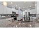 A view of kitchen featuring a large granite countertop, stainless appliances, and white cabinets at 1569 Shannon Falls Dr, Fort Mill, SC 29715